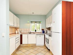 a kitchen with white appliances and a window at 8 person holiday home in Bl vand in Blåvand