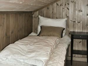 a large white bed in a room with wooden walls at 5 person holiday home in F vang in Favang