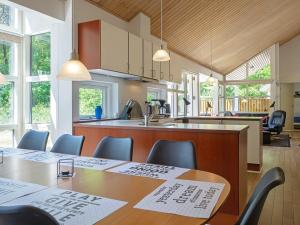une cuisine et une salle à manger avec des tables et des chaises dans l'établissement 8 person holiday home in Hasle, à Hasle