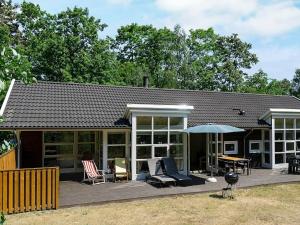 Casa con terraza con sillas y sombrilla en 8 person holiday home in Hasle, en Hasle