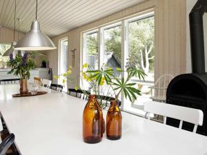 Mosevråにある10 person holiday home in Oksb lの台所のテーブルに座ってボトル2本