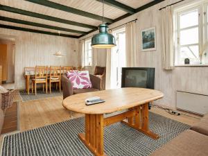 un salon avec une table en bois et une télévision dans l'établissement Holiday Home Horns Rev III, à Blåvand