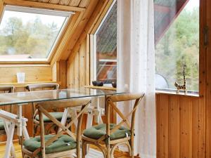 ein Esszimmer mit einem Tisch, Stühlen und einem Fenster in der Unterkunft Holiday Home Litlevågen in Bysheim