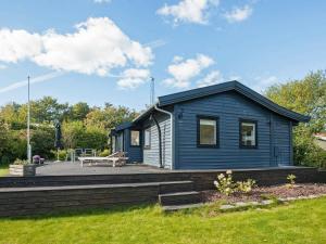 a blue tiny house with a wooden deck at Charming Beach House - By Traum Ferienwohnungen in Vejby