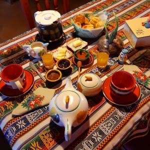 a table with a tea pot and cups and food at Cabañas "Los Elementos", San Carlos, Salta, in San Carlos