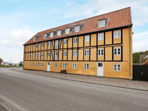 BandholmにあるHoliday Home Havnepladsenの通り側の大きなオレンジ色の建物