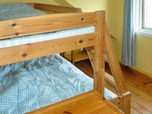 a wooden bunk bed in a room with a bed at 8 person holiday home in Sørbøvåg in Sørbø