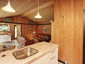 a kitchen with a sink and a living room at 6 person holiday home in L s in Læsø