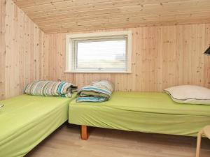 zwei Betten in einem kleinen Zimmer mit Fenster in der Unterkunft 6 person holiday home in Hirtshals-By Traum in Hirtshals