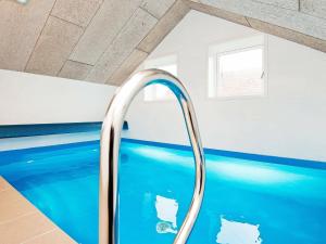 a swimming pool with a blue tub in a room at Holiday Home Pøt Strandby IX in Sønderby