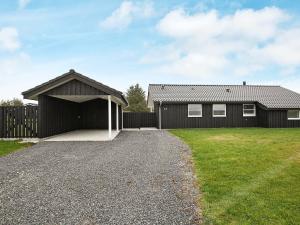 ein Haus mit einer Garage neben einem Hof in der Unterkunft 6 person holiday home in Hirtshals-By Traum in Hirtshals