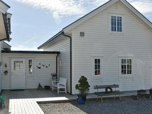 eine weiße Scheune mit einem Tisch und einem Stuhl auf einer Terrasse in der Unterkunft 10 person holiday home in Tornes I Romsdal in Tornes
