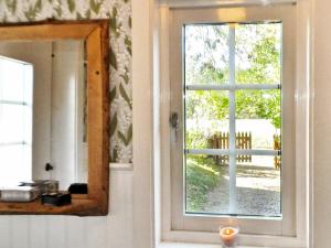 um espelho ao lado de uma porta com uma janela em 8 person holiday home in Varg n em Västra Tunhem