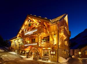 a building in the snow at night at Hôtel Chalet Mounier in Les Deux Alpes