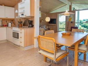 Ørbyにある6 person holiday home in Knebelのキッチン、ダイニングルーム(木製のテーブルと椅子付)