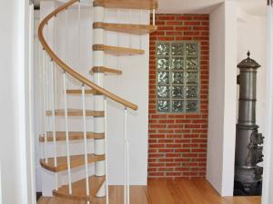 a spiral staircase next to a brick wall at 5 person holiday home in S DER KRA in Söderåkra