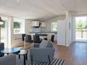 Il comprend un salon avec un canapé et des chaises ainsi qu'une cuisine. dans l'établissement 6 person holiday home in L kken, à Løkken