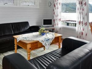 SeljeにあるHoliday Home Rundereimのリビングルーム(黒革の家具、テーブル付)