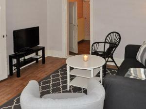 uma sala de estar com um sofá e uma mesa com uma vela em 8 person holiday home in Varg n em Västra Tunhem
