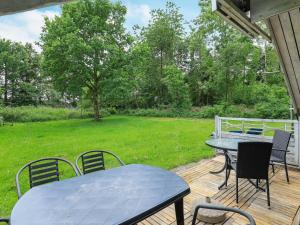a patio with a table and chairs on a deck at 6 person holiday home in Roslev in Vester Grønning