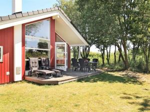 a house with a deck with chairs and a table at Three-Bedroom Holiday home in Großenbrode 8 in Großenbrode