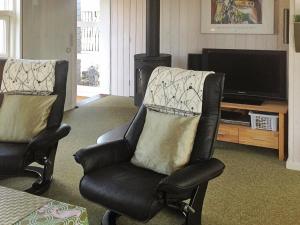 een woonkamer met 2 stoelen en een televisie bij 4 person holiday home in Hejls in Hejls