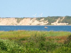 dos molinos de viento y un barco en un cuerpo de agua en 6 person holiday home in H jslev, en Bøstrup