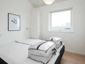 ハザスレウにあるHoliday home Haderslev XIの白いベッドルーム(ベッド2台、窓付)