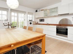 Rørvigにある4 person holiday home in Nyk bing Sjのキッチン(木製テーブル、白いキャビネット付)