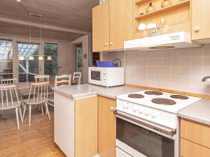 a kitchen with white appliances and a dining room at 8 person holiday home in Vejers Strand in Vejers Strand