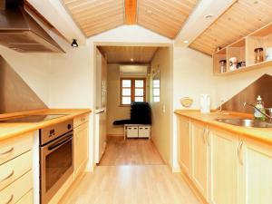 una cocina con armarios de madera y fregadero en 9 person holiday home in J gerspris en Jægerspris