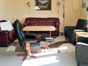 a living room with a couch and a table and chairs at 6 person holiday home in Dyrvik in Dyrvik