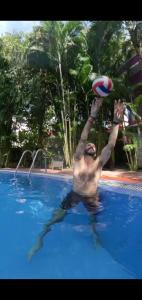 a man in a swimming pool playing with a frisbee at Wilson Ayurvedic Beach Resorts in Kovalam