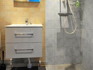 La salle de bains est pourvue d'un lavabo et d'une douche. dans l'établissement 3 person holiday home in R nn ng, à Rönnäng