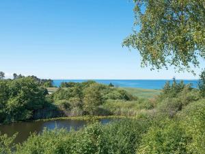 Ørbyにある6 person holiday home in Knebelの木々と海を背景にした川