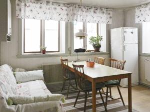 a kitchen and dining room with a table and a refrigerator at Holiday Home Västra IV in Lysekil