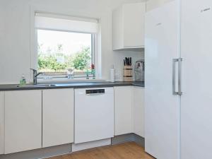 une cuisine blanche avec un évier et une fenêtre dans l'établissement 6 person holiday home in L kken, à Løkken