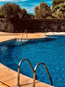 uma piscina com água azul num quintal em les reflets em Saint-Cyprien-Plage