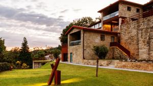 ein Haus mit einer Skulptur davor in der Unterkunft Agrinho Suites & Spa Gerês in Valdosende