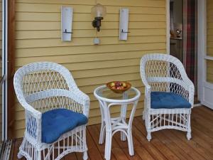 dos sillas de mimbre y una mesa en un porche en Holiday home Mönsterås V, en Mönsterås