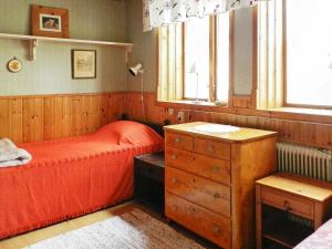 sypialnia z łóżkiem, komodą i oknami w obiekcie Holiday Home Västra IV w mieście Lysekil