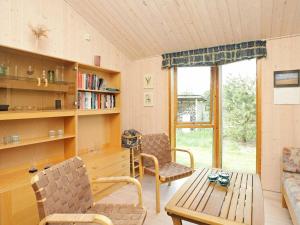 Torup Strandにある6 person holiday home in Fjerritslevのリビングルーム(テーブル、椅子、窓付)