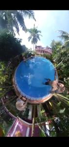 a group of people standing around a swimming pool at Wilson Ayurvedic Beach Resorts in Kovalam