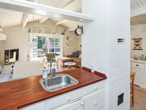 a kitchen with a sink and a living room at 6 person holiday home in Jerup in Jerup
