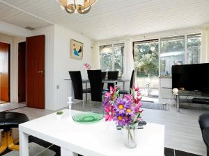 una sala de estar con una mesa blanca con un jarrón de flores en 5 person holiday home in Vejers Strand, en Vejers Strand