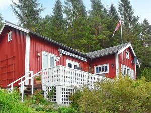 a red house with a white porch and a flag at Holiday Home Hansbakken in Molde