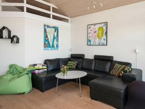 エーベルトフトにある6 person holiday home in Ebeltoftのリビングルーム(黒い革張りのソファ、テーブル付)