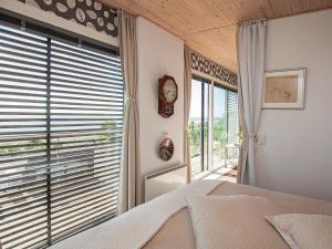 a bedroom with a bed and a window with a clock at 2 person holiday home in Slagelse in Slagelse