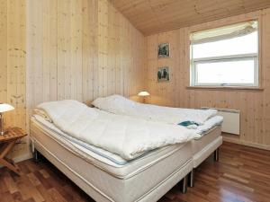 ein großes Bett in einem Zimmer mit Fenster in der Unterkunft Holiday home Hirtshals IV in Hirtshals