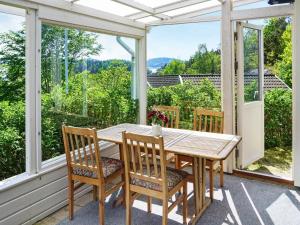 einen Holztisch und Stühle auf einer Veranda mit Aussicht in der Unterkunft 6 person holiday home in MUNKEDAL in Munkedal